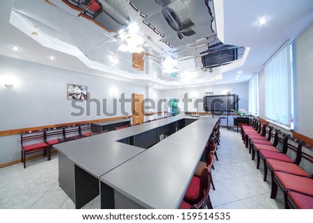 Long table, modern armchairs in empty room for business meetings