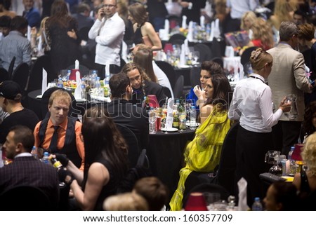 MOSCOW - MAY 25: Russian celebrities sit at tables on Russian Music Award channel RUTV in Crocus City Hall on May 25, 2013 in Moscow, Russia. Focus on a girl in yellow dress.