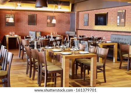 Restaurant room with wooden furniture and walls of red bricks