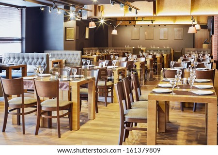 Restaurant Hall With Wooden Furniture And Walls Of Red Bricks