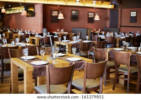 Restaurant Roomy Hall With Wooden Furniture And Walls Of Red Bricks
