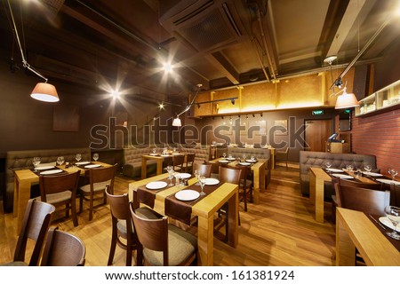 Interior Of Room In Restaurant With Wooden Furniture And Walls Of Red Bricks