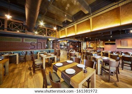 Interior Of Cafe-Bar With Wooden Furniture And Walls Of Red Bricks