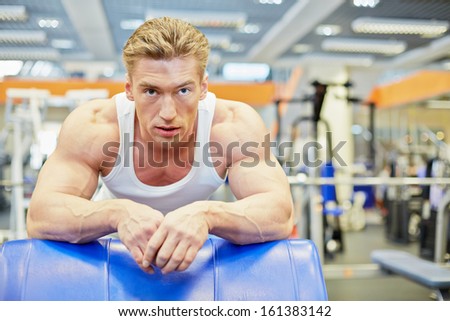 Man gets some rest between exercises in gym hall