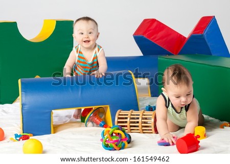 Two funny toddlers are playing with toys in the gaming complex