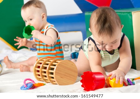 Two babies are playing with toys in the gaming complex