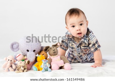 Baby boy playing with knitted toys in studio