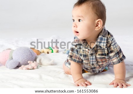 Baby boy in shirt with stuffed toys in studio