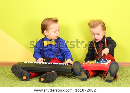 Two mods boy in bright clothes with a toy piano and metallophone