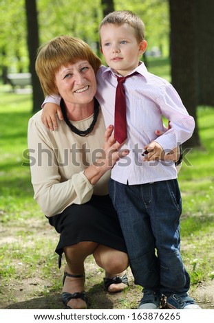 Grandmother with her grandson embracing in the park on a sunny day