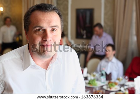 Portrait of the man in the restaurant on background of a banquet table