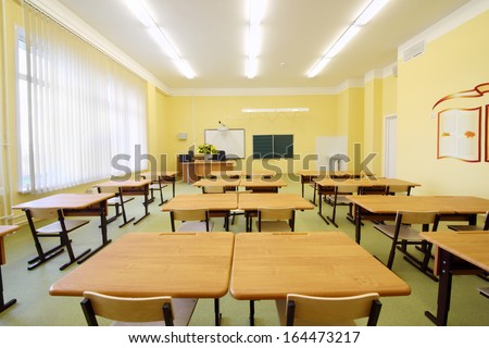Empty Classroom With Wooden Desks, White And Green Chalk Boards In School.