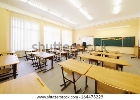Empty Classroom With Wooden Desks, Chalk Board And Big Windows In School.