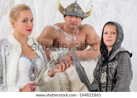 Family of three in historical costume viking with sword and helmet