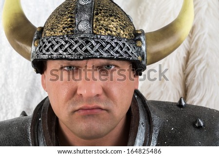 A strict man in costume viking with a helmet