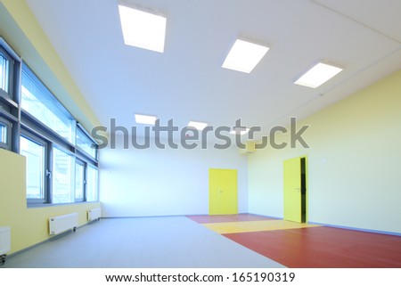 The playroom with yellow walls and large windows in the kindergarten