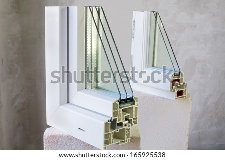 Two sample of PVC windows stands on a concrete block on a concrete wall background