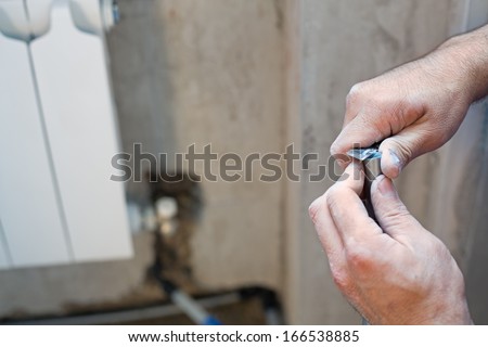 A worker cleans the pipe preparing it for crimping