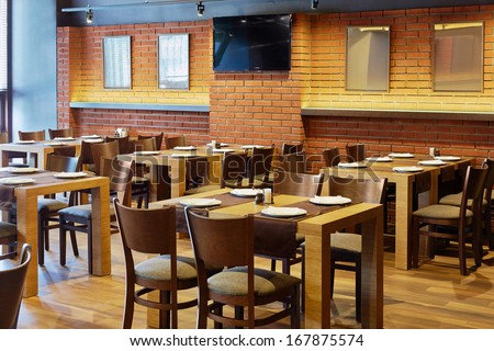 Interior of cafe-bar with wooden furniture and walls of bricks