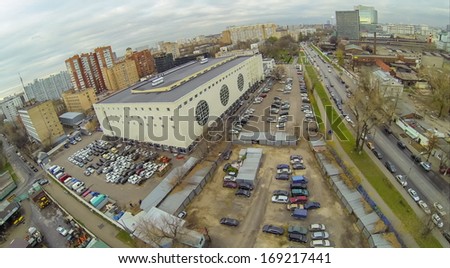 Cityscape with skyscrapers and large car parking with garages, view from unmanned quadrocopter.