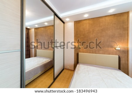 Modern bedroom with closet and large mirror