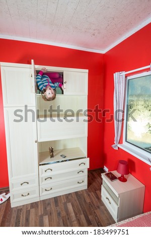 Little girl upside down in open closet at inverted house