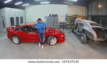 MOSCOW, RUSSIA - DEC 24, 2013: (aerial view) Man in car service. In 2014, price increase in car services will be 3-5 per cent.