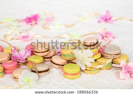 Colorful cookies with cream on table with flowers and ribbon