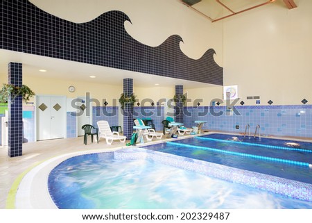 MOSCOW, RUSSIA - MAY 8, 2014: Indoor pool of fitness center Gold Gym with traineger equipments. In Russia, Gold Gym opened in 1996.