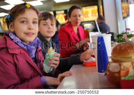 Mother with two kids have a snack in a fast food restaurant