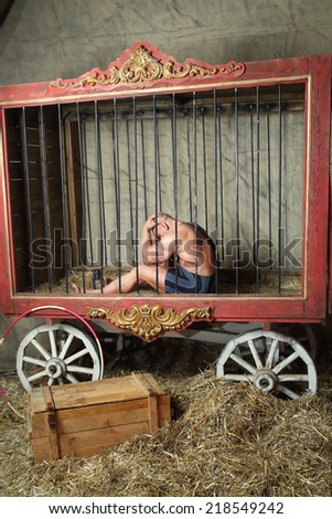 Sad athlete sits with his head in his hands in cage for animals