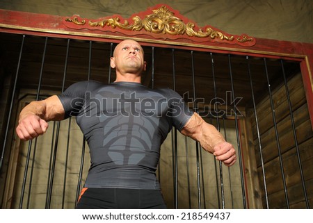 Strong man with stern look around cage for wild animals