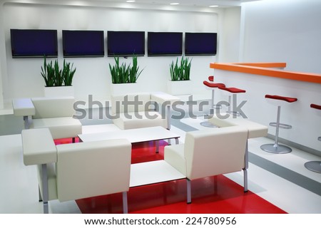 Empty waiting area with white chairs and plasma screens in office