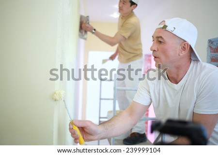 Two builders making finish in the apartment