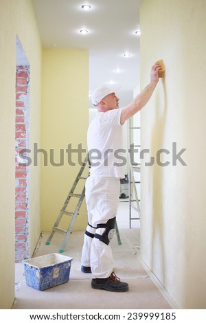 Finisher polishing the wall using a sanding sponge
