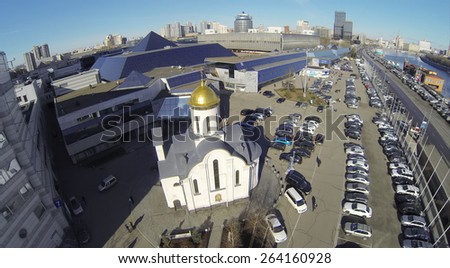 MOSCOW, RUSSIA - MAR 12, 2013: Church and car parking near Expo Center exhibition complex against cityscape at sunny day. Aerial view