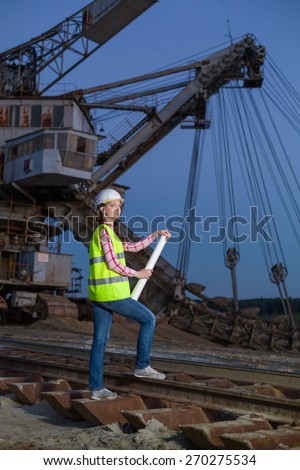 female worker standing on rails on backgroud of career stacker