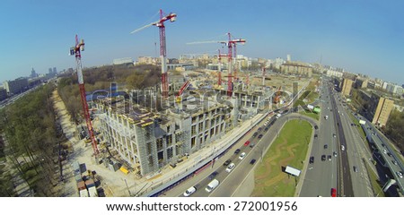 Construction site with lots of cranes next to the road, aerial view