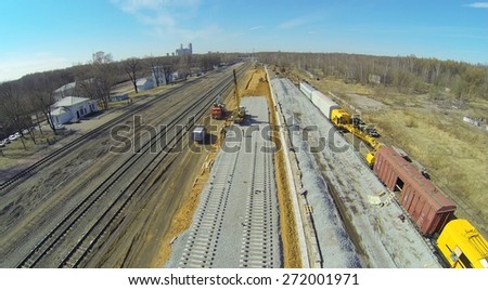 Workers are building the railroad tracks near the old tracks, aerial view