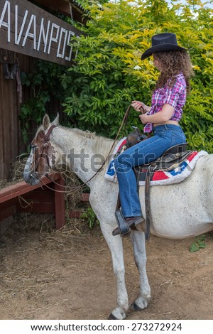 cowboy woman in a hat on a horse