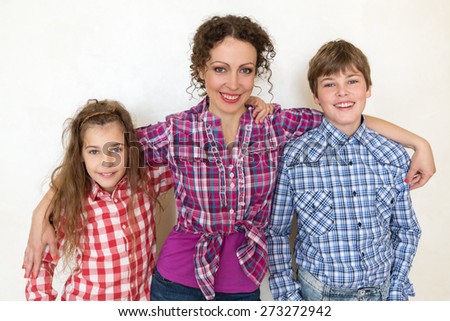 mother with two children posing on white background closeup