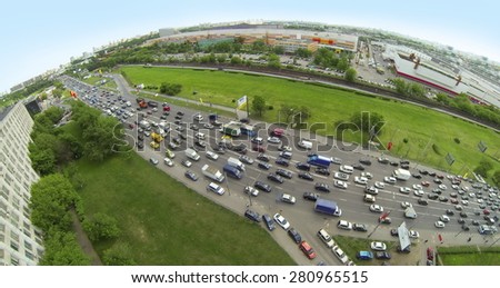 RUSSIA, MOSCOW - MAY 14, 2014: Many cars ride on Volgogradsky avenue by highway near Renault auto show and Avtoframos company. Panorama