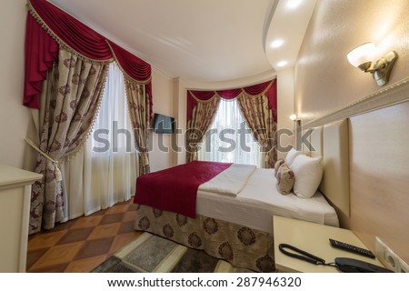 ADLER, RUSSIA - JULY 22, 2014: Interior of a hotel room with drapes and high bed in Shine House hotel