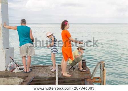family of four go fishing on the docks