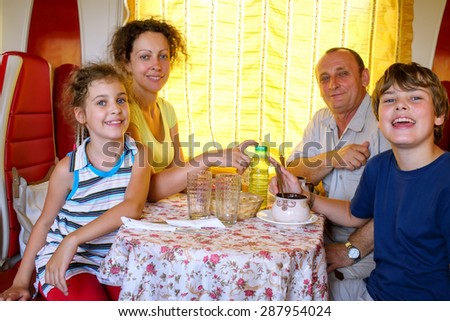 family of four posing at a table in the dining car of the train