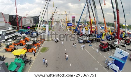 RUSSIA, MOSCOW - JUN 6, 2014: People walk near machines on International Specialized Exhibition of Construction Equipment and Technologies CET 2014 at  Crocus Expo. Photo with noise from action camera