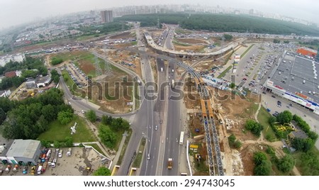 RUSSIA, MOSCOW - MAY 28, 2014: Electric power line near building site of Borovskaya flyover and transport traffic on beltway in spring cloudy day. Aerial view
