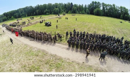 RUSSIA, NELIDOVO - JUL 12, 2014: Formation of soldiers in uniform of soviet and german armies during reconstruction Battlefield at sunny day. Aerial view. Photo with noise from action camera.