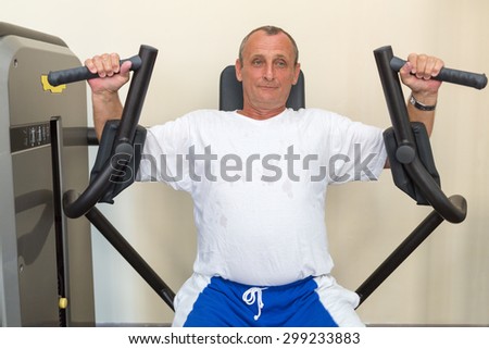 elderly man on a weight machine in the gym