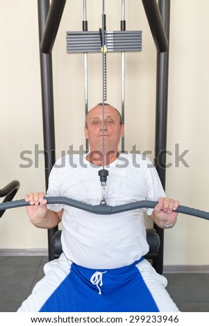 elderly man on weight machine in the gym